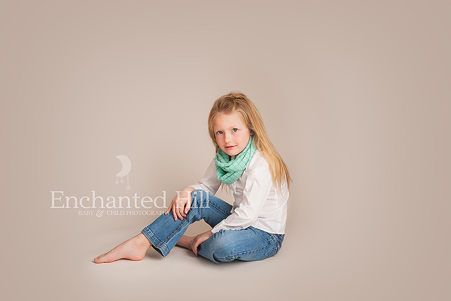 Little girl with blond hair posing for a studio pictures
