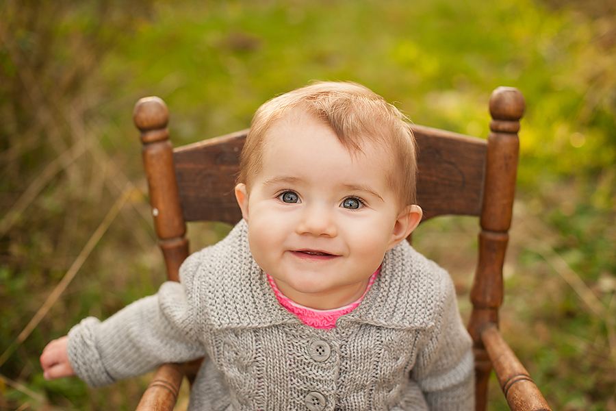  baby wearing a grey sweater sitting in a chair