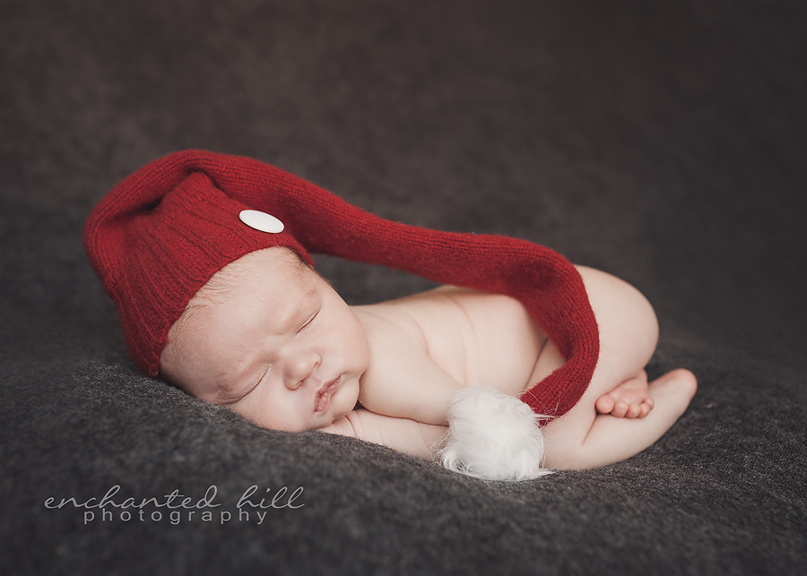 newborn baby sleeping with red hat on