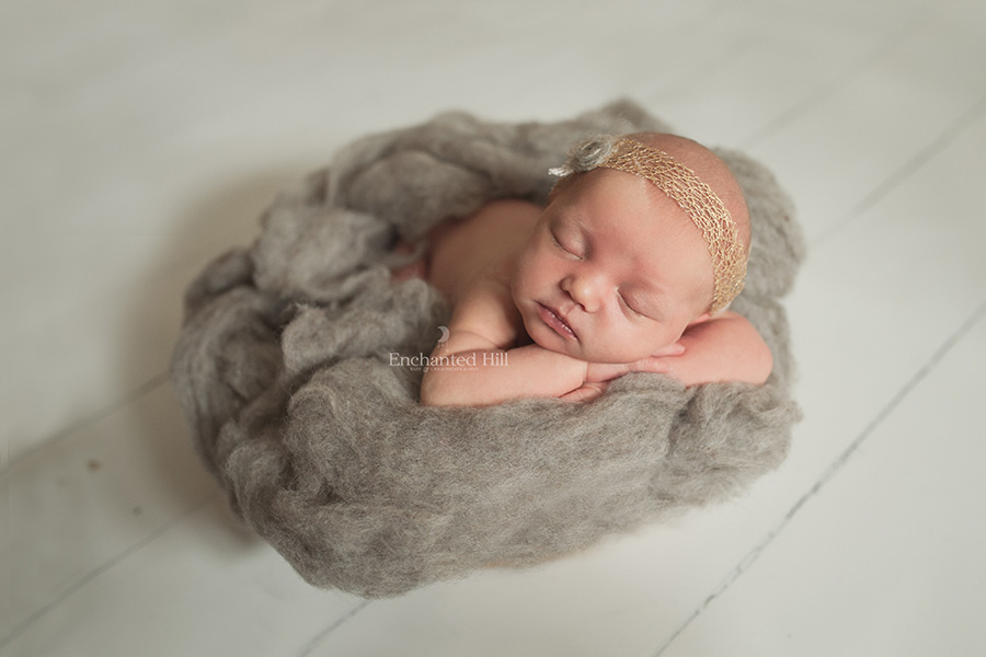 baby girl laying on grey wool