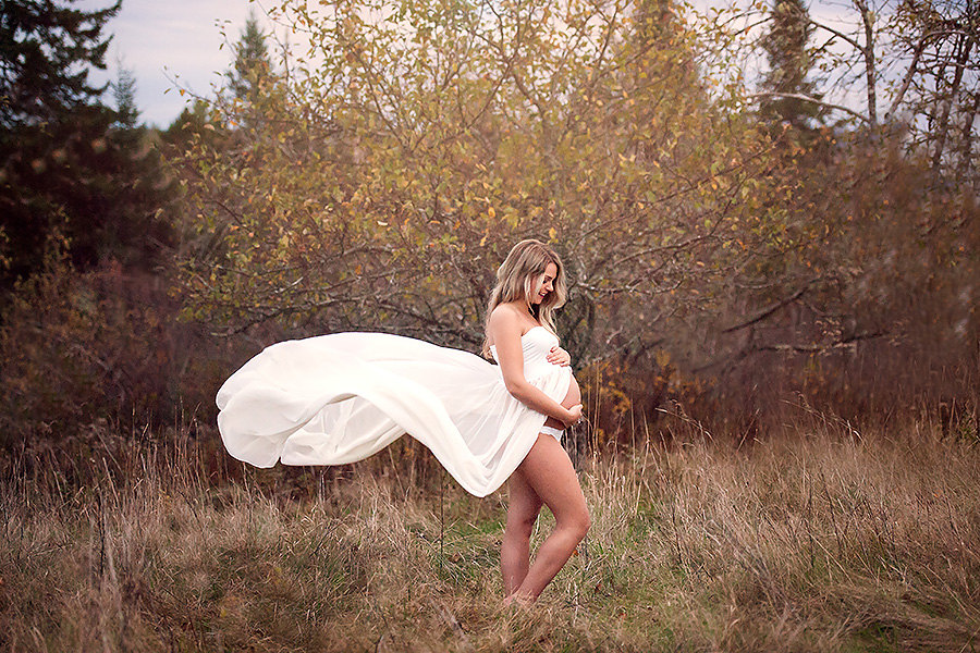 stunning maternity session flowing white gown in a field
