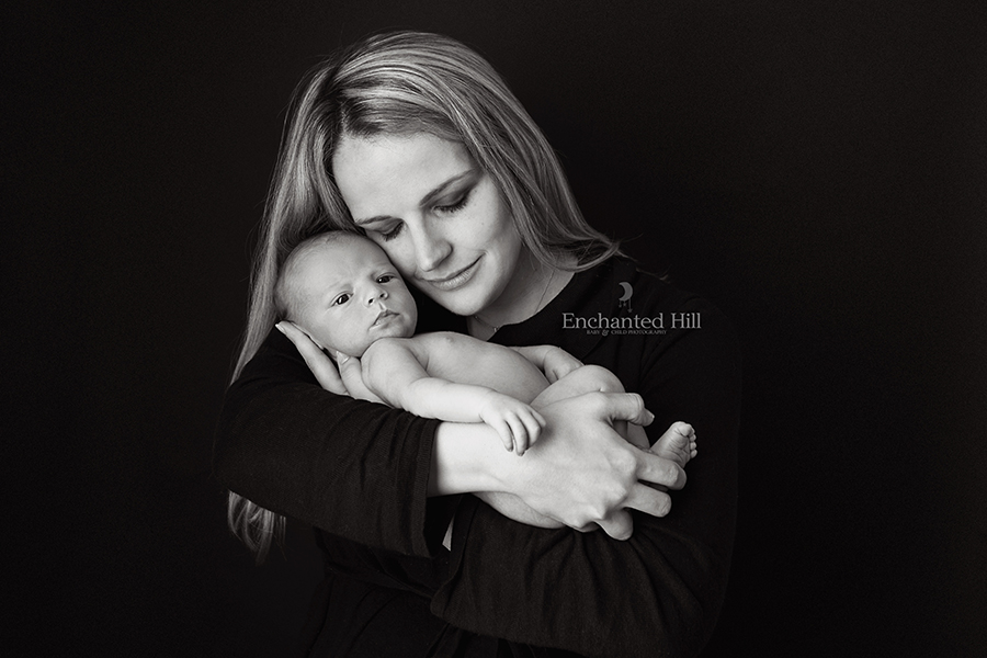 black and while image of a Mom holding her awake newborn