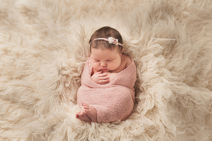 baby girl wrapped in pink scarf