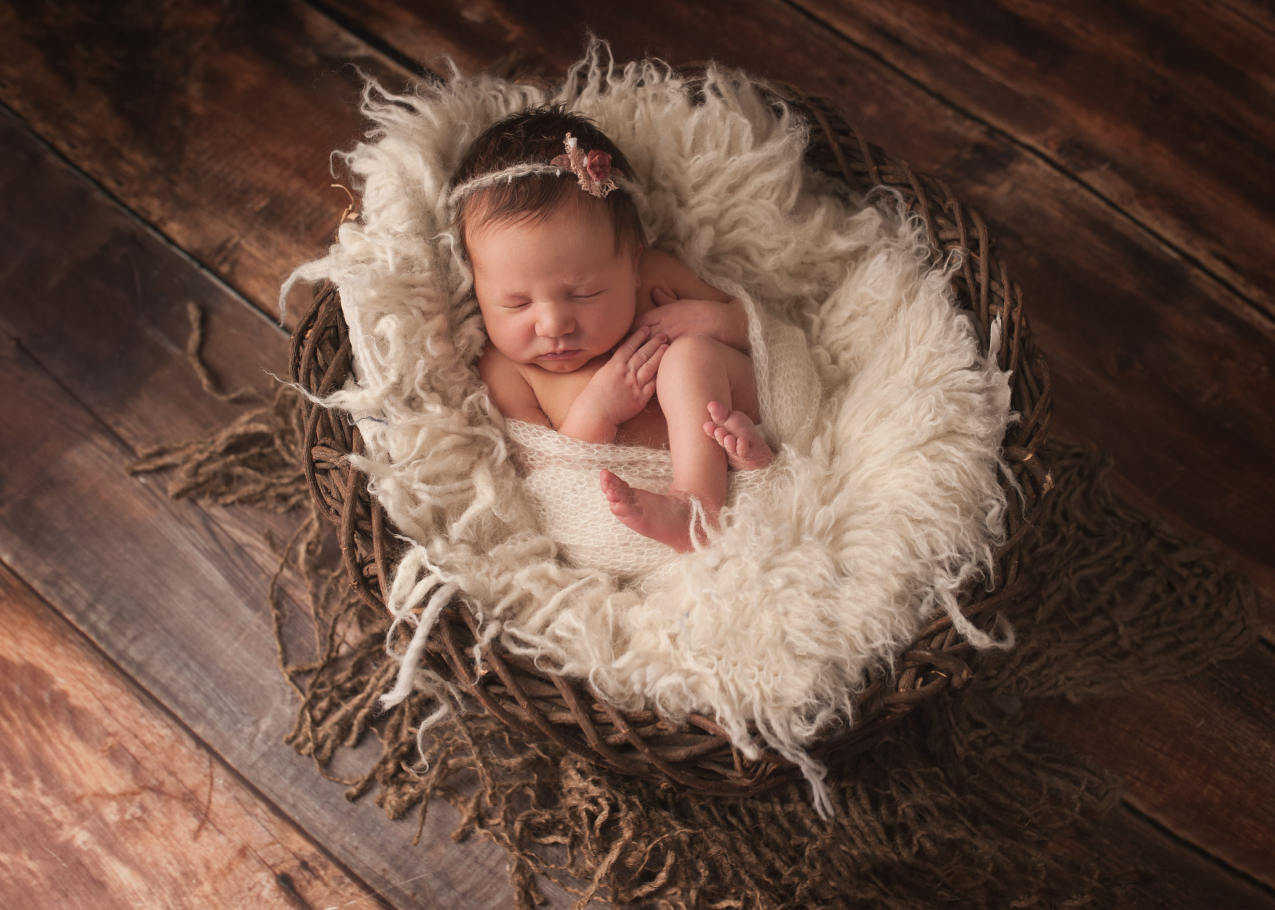 newborn baby laying of fur rug