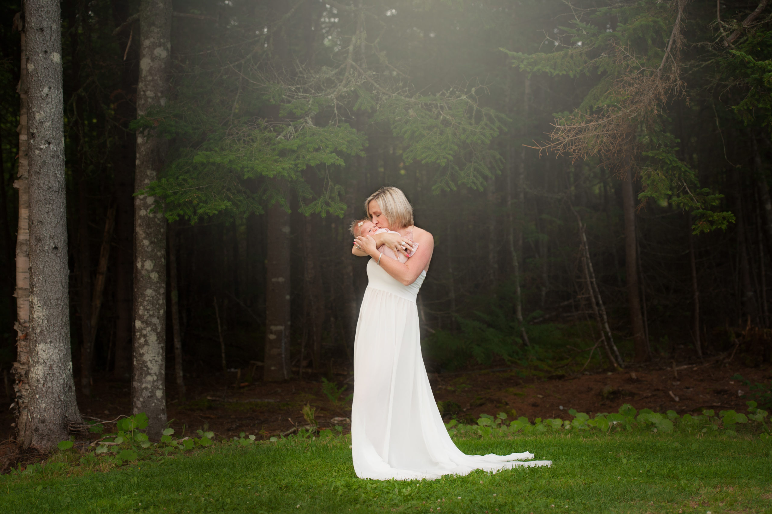 Saint John photographer new mom holding her new baby in white gown