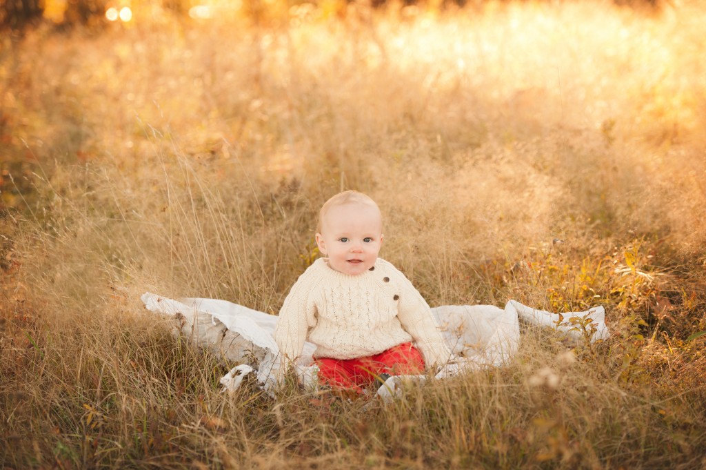 Saint John Baby Photographer takes picture of little baby sitting in field