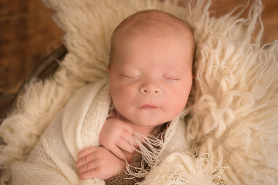 Saint john photographer - newborn baby laying on cream rug