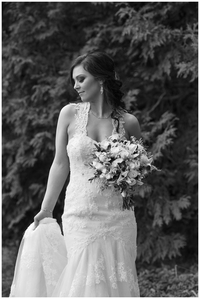 black and white image of a bride look down at her dress
