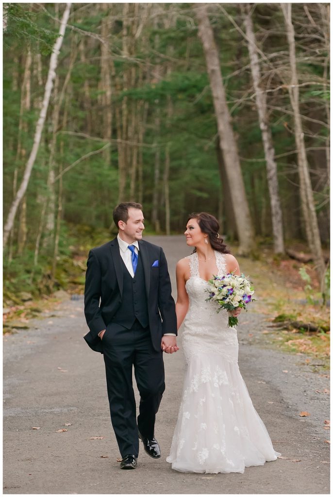 bride and groom walking through the woods at Odell Park in the fall