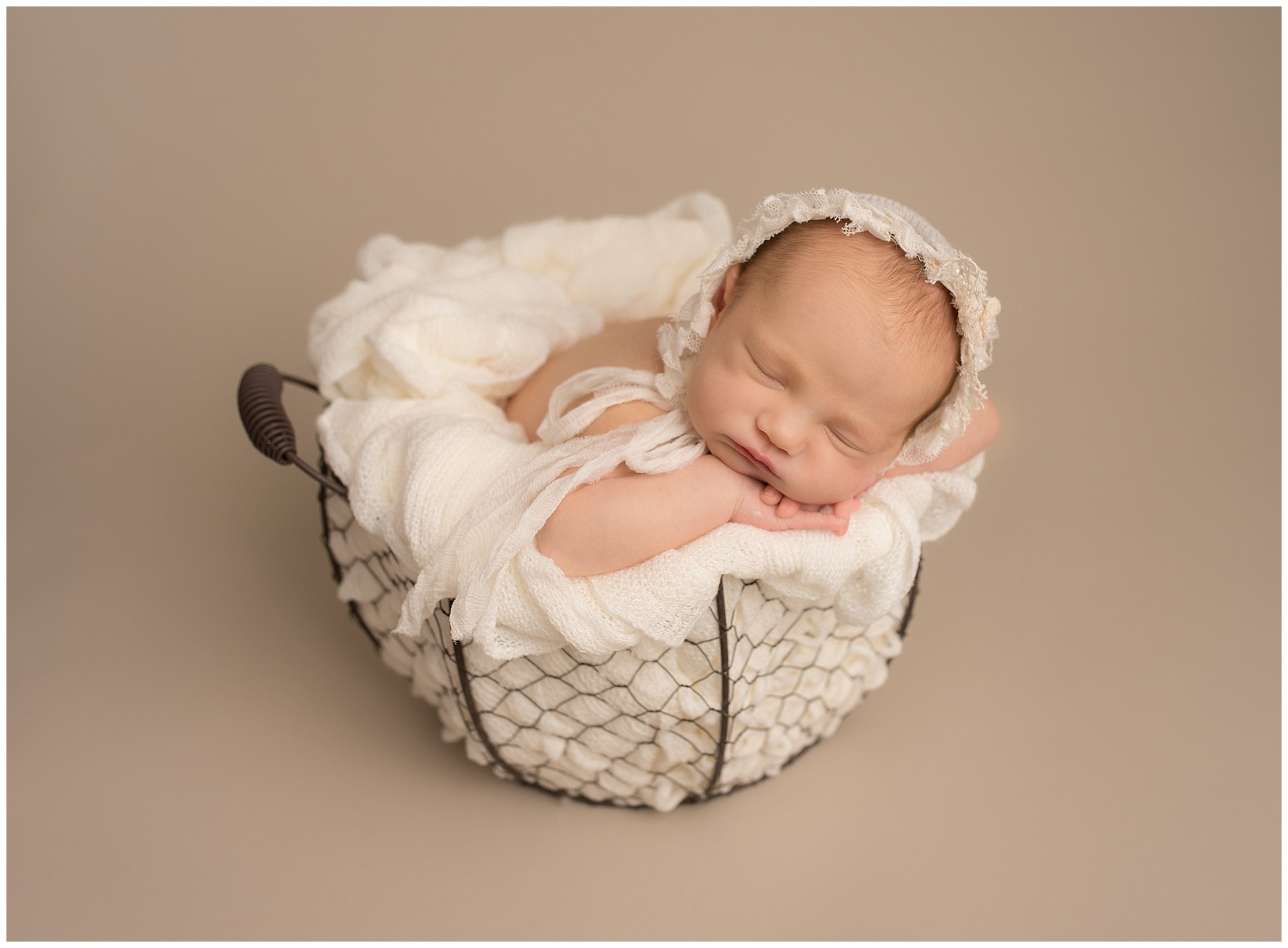 sleeping baby girl wear a cream bonnet and sleeping in an egg basket