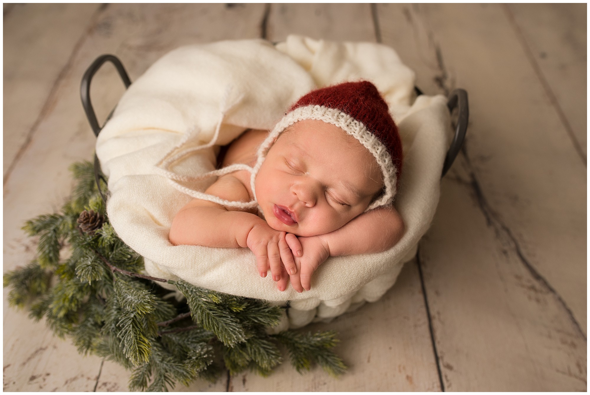 baby sleeping in a basket that is decorated for Christmas