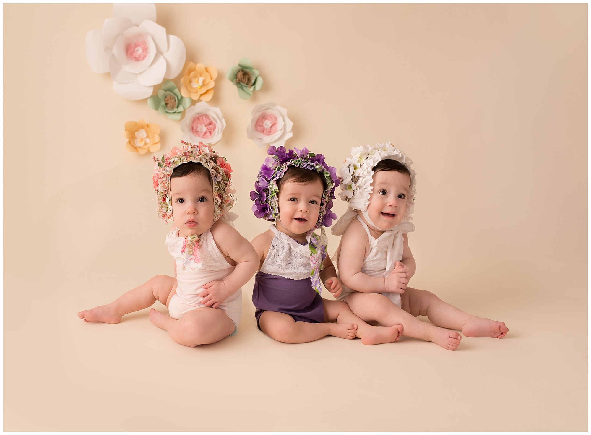 triplet girls wearing flower hats 