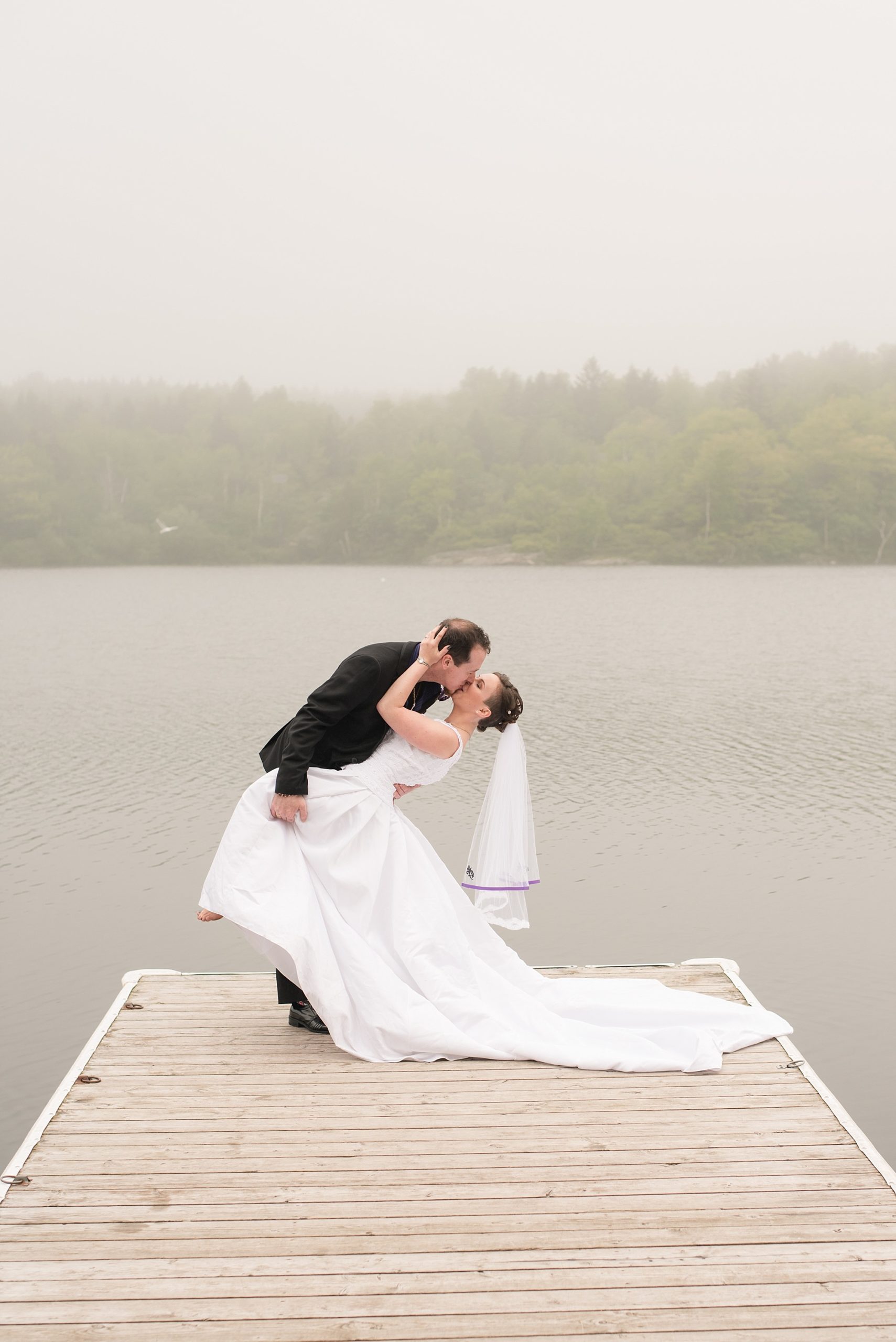 bride and groom kissing on the dock at Lily Lake pavilion