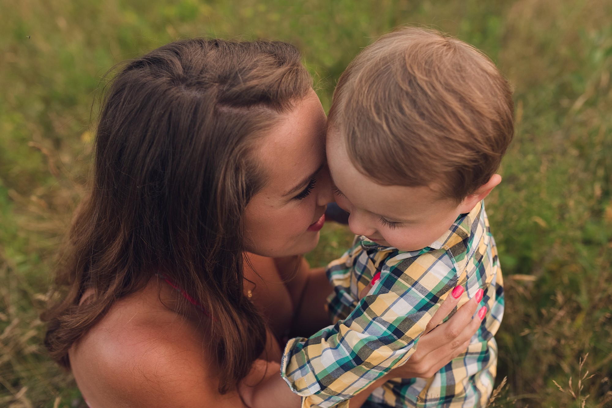 Mother snuggling her toddler son during a family photo session