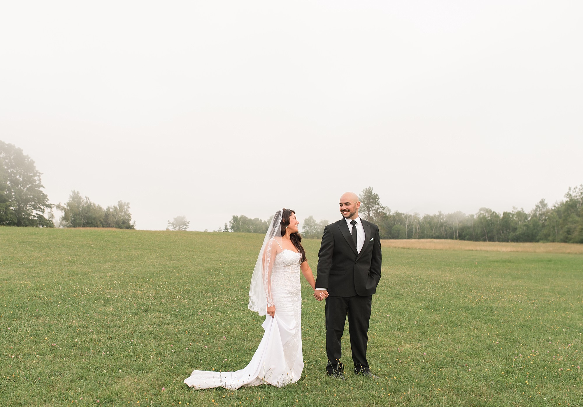 wedding couple standing in a field in Ganong Park, St Stephen, new Brunswick