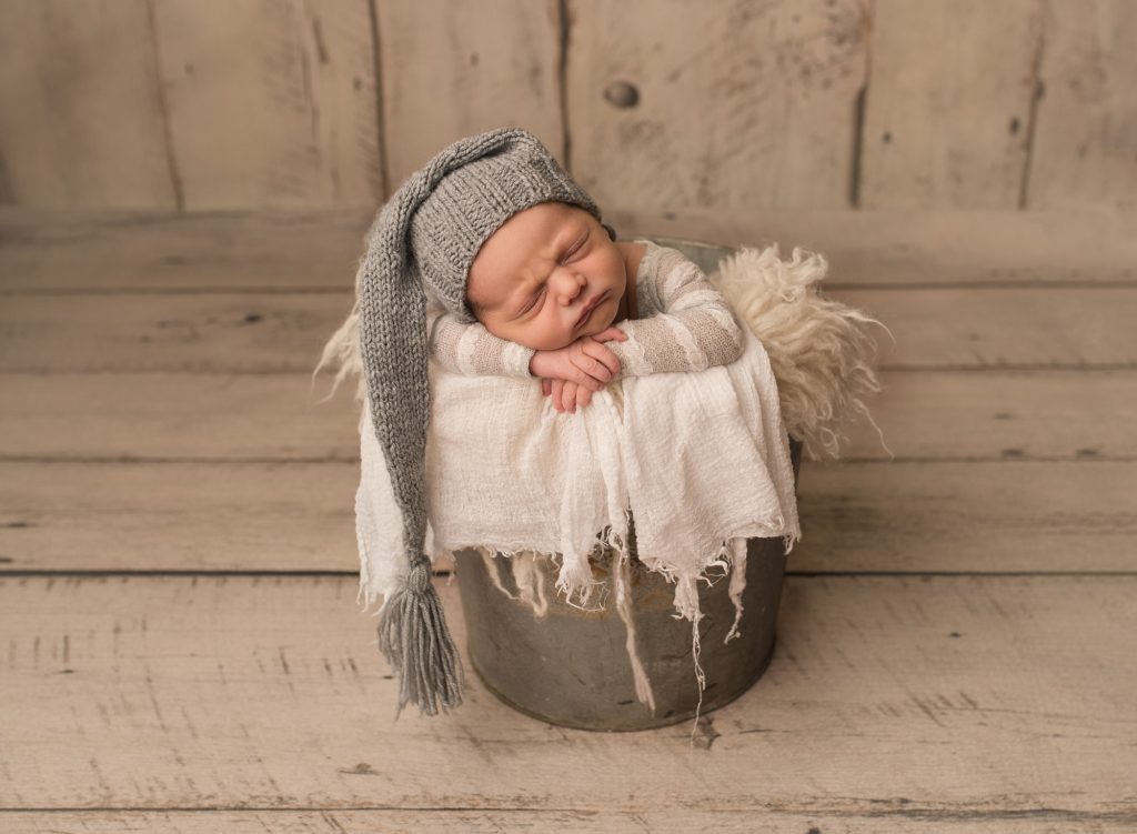 newborn baby in Saint John in a bucket with a grey knitted hat