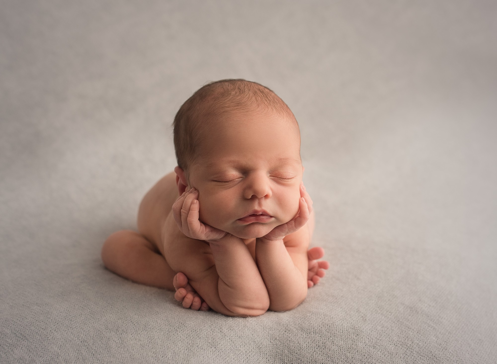 newborn baby posed on a blanket doing the froggie pose