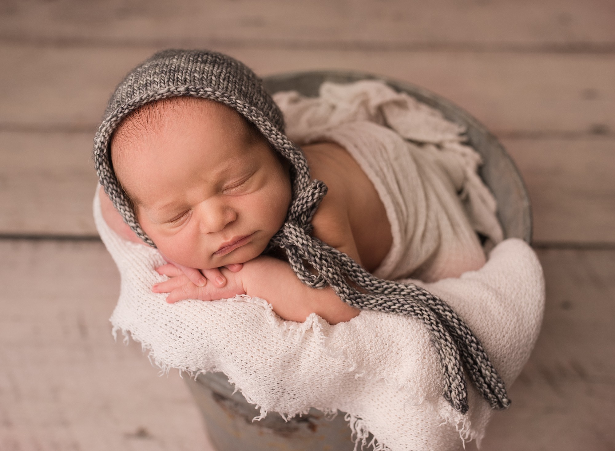 baby in a grey bonnet