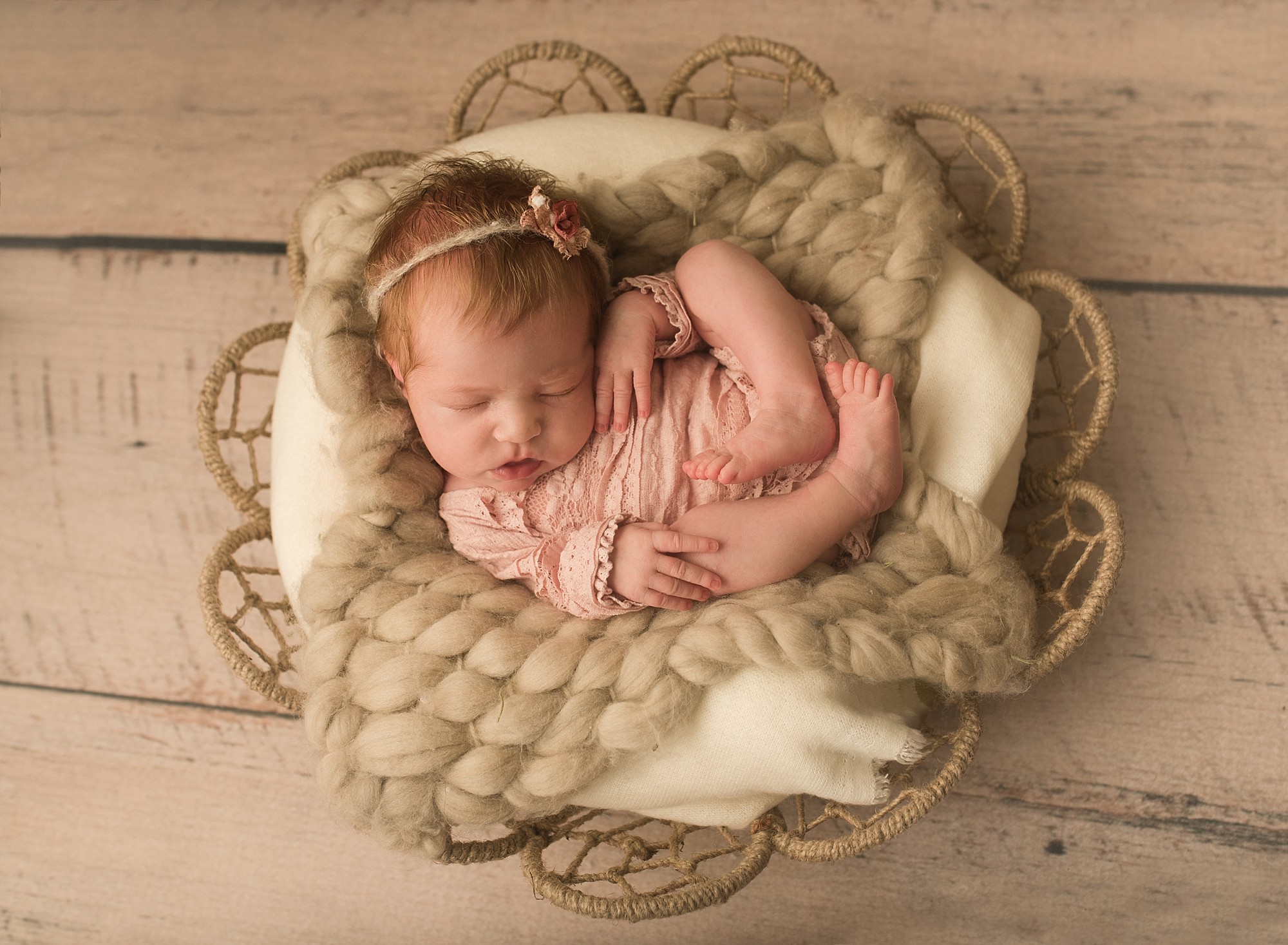 newborn girl wearing pink romper