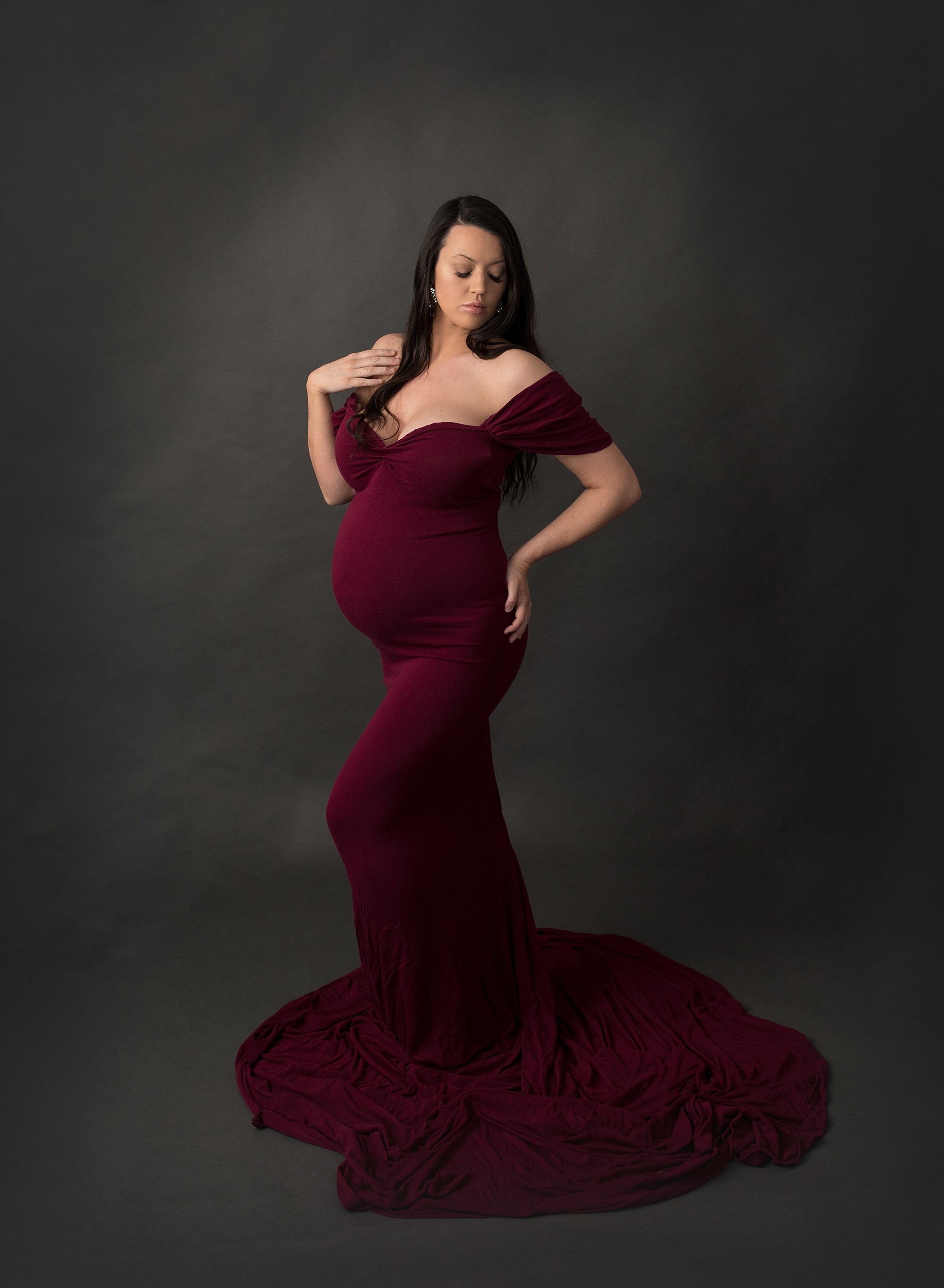 elegant and gorgeous pregnant woman wearing a wine coloured dress