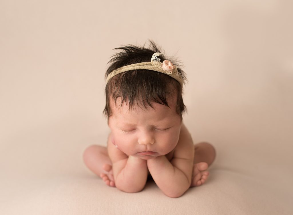 sleeping baby posed for a picture wearing a floral headband