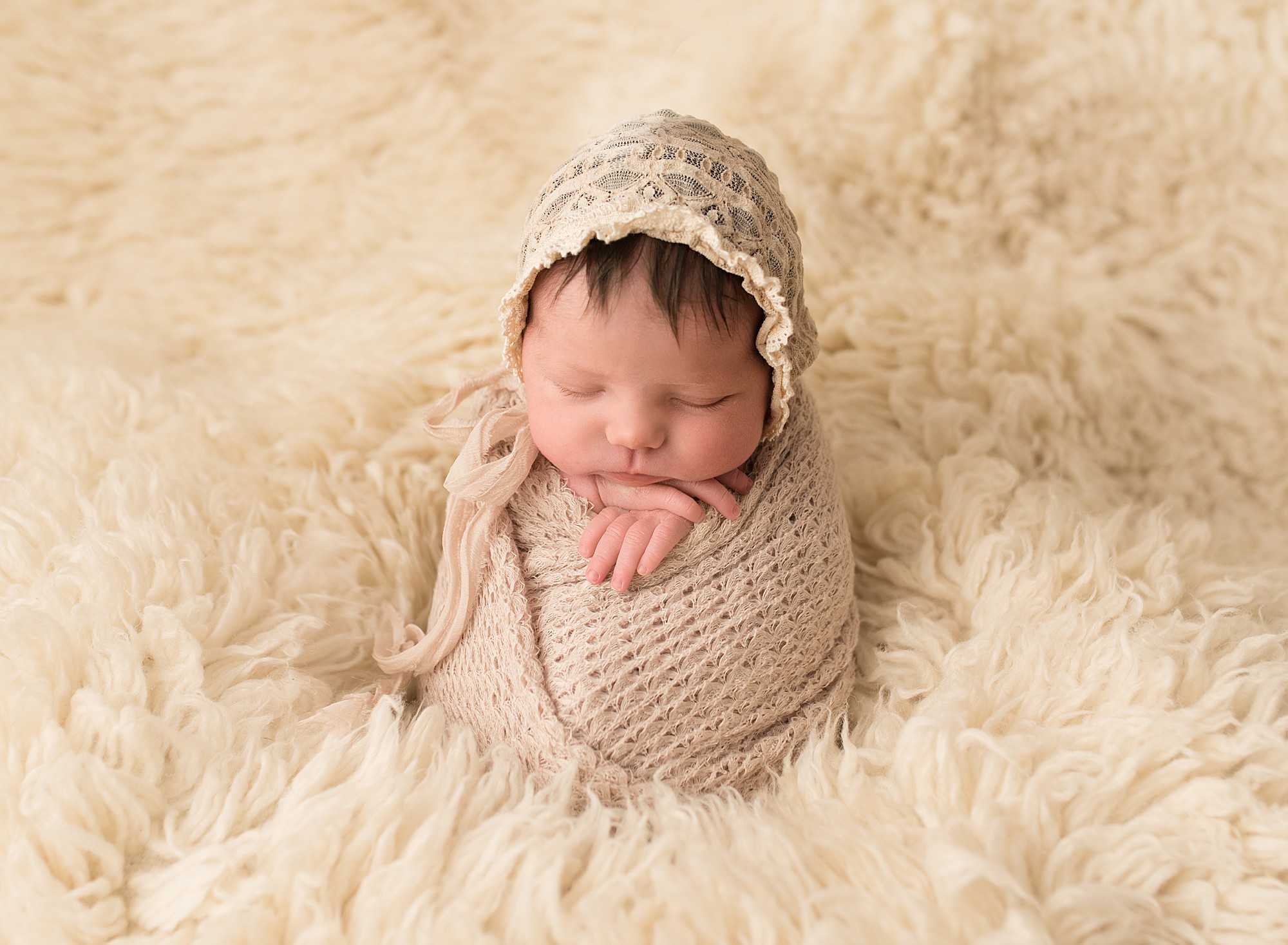 newborn baby girl sleeping and wrapped in antique scarves
