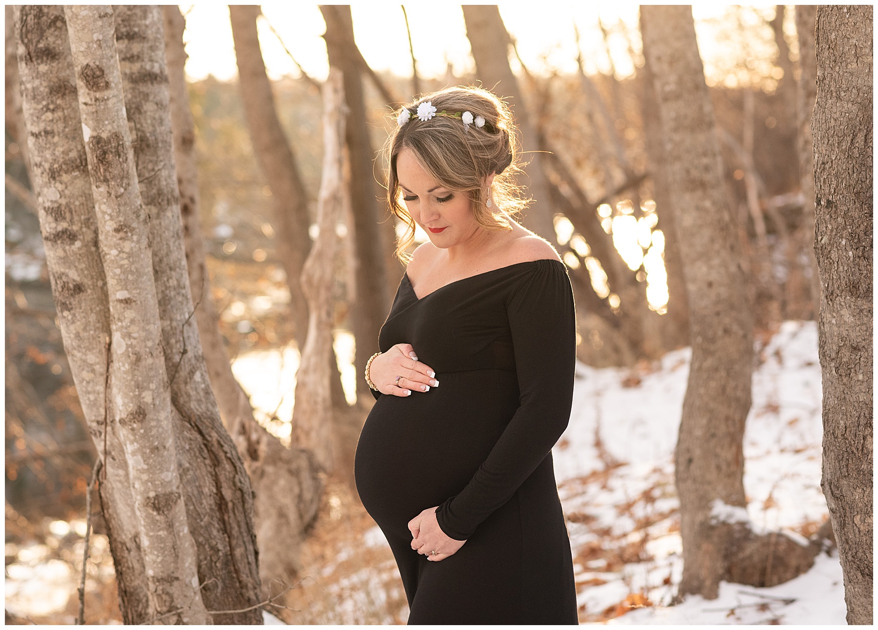 woman in black dress holding pregnant belly wearing a black dress