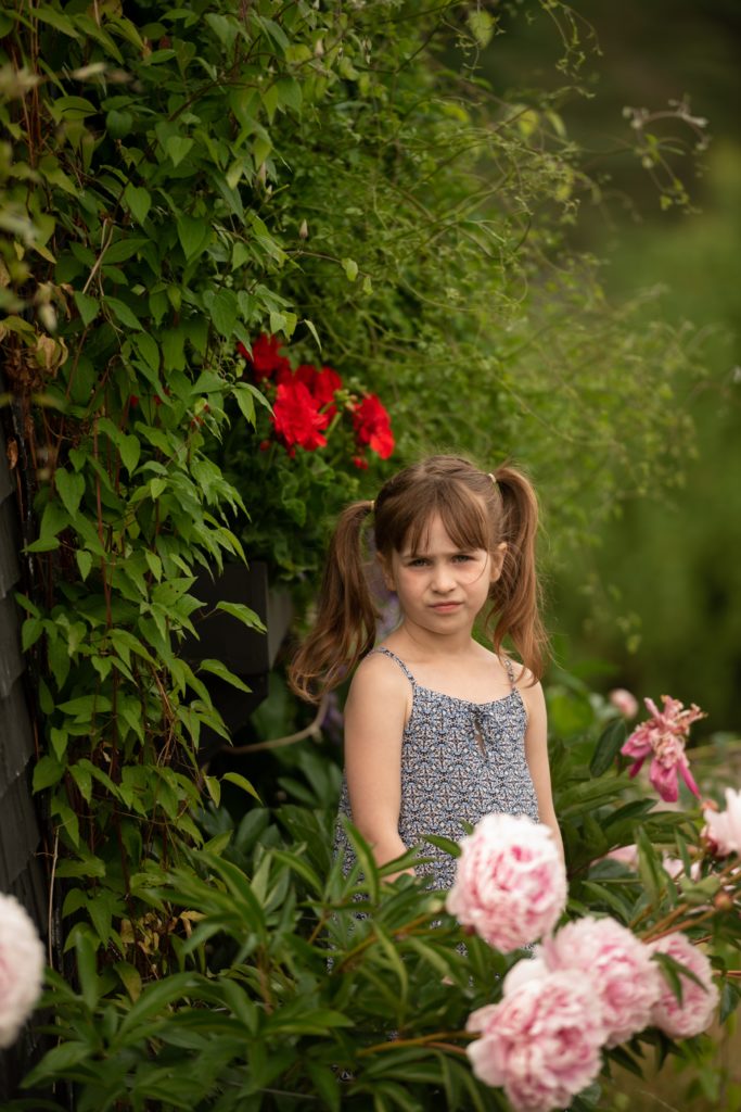 little girls posing next the the ivy covered shed in Kingsbrae Gardens