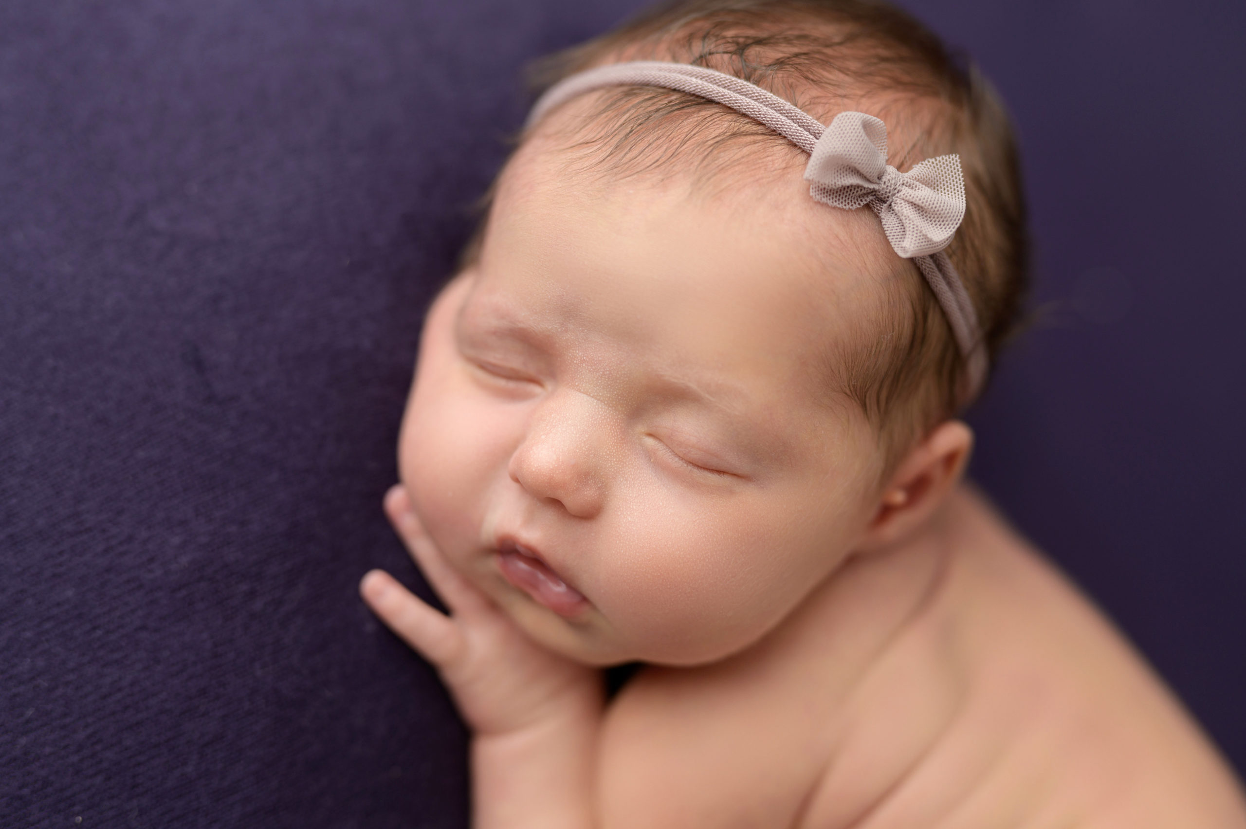 newborn baby sleeping on purple