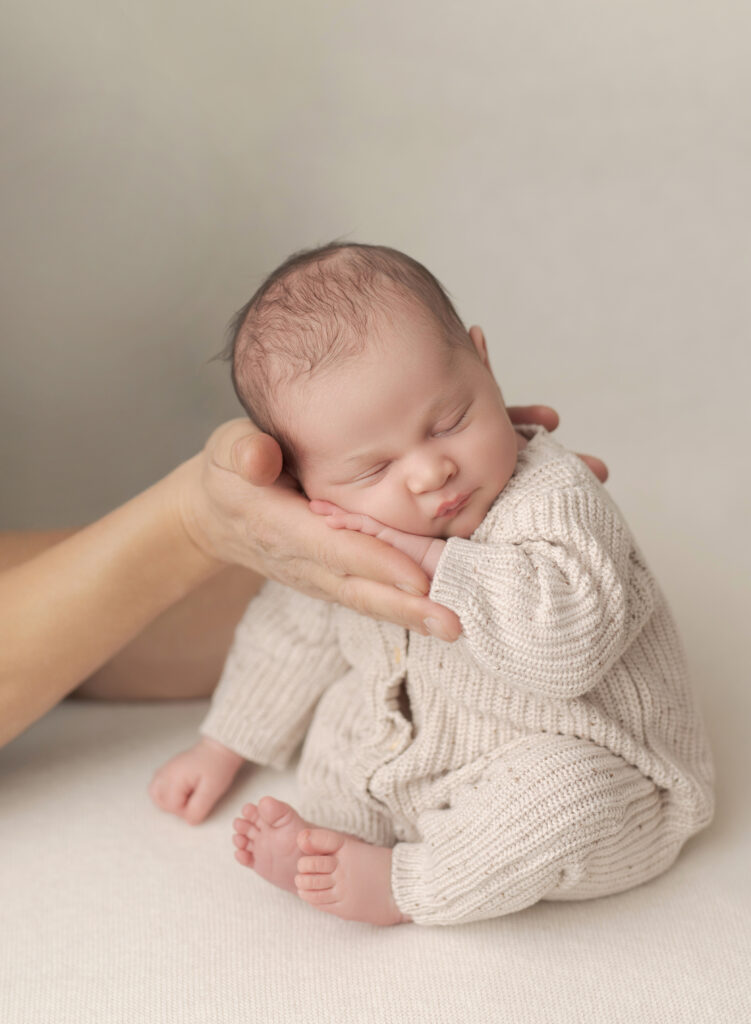 newborn being held in their parent's hands 